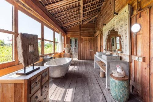 La grande salle de bains est pourvue d'une baignoire et d'un lavabo. dans l'établissement Alami Boutique Villas & Resort, à Tabanan