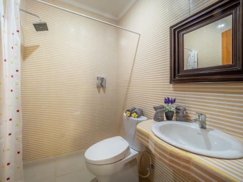 a bathroom with a toilet and a sink at Tiis Garden Puri Villas in Gianyar