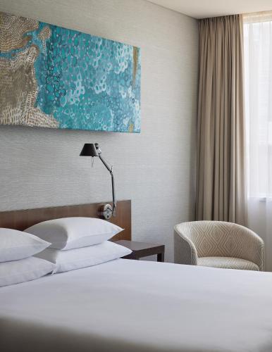 a hotel room with a bed and a chair at Hyatt Regency Brisbane in Brisbane