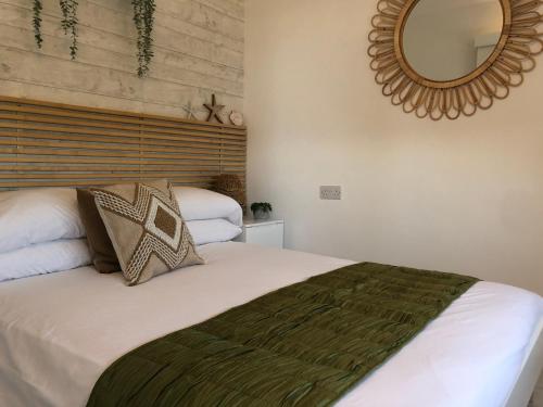 a bedroom with a large bed and a mirror at Ocean Drive 1 Boutique Apartment Brean Down in Brean