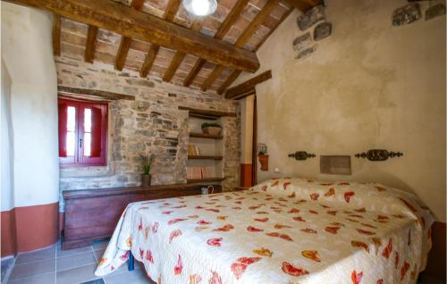 ein Schlafzimmer mit einem Bett in einem Zimmer mit einer Steinmauer in der Unterkunft Amazing Apartment In Villagrande Di Monteco With House A Panoramic View 