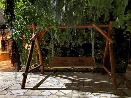 a wooden swing sitting under a tree at EleGaya Guest house in Ijevan