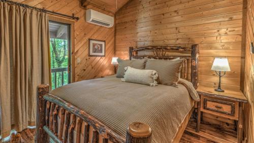 Un dormitorio con una cama en una cabaña de troncos en Away to the Lake, en Blue Ridge