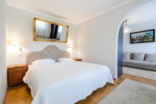 a bedroom with a white bed and a couch at Rezydencja Czantoria & Spa in Ustroń