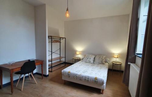 1 dormitorio con cama, escritorio, mesa y silla en L'Auberge du Campos, en Saint-Pierre-Duchamp