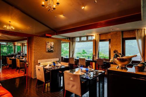 a dining room with tables and chairs and windows at Hakone Fontaine Bleau Sengokutei in Hakone