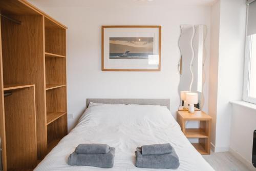 um quarto com uma cama com duas almofadas em Barry Island Beachfront Apartment - Stunning Bay Views and Private Parking em Barry