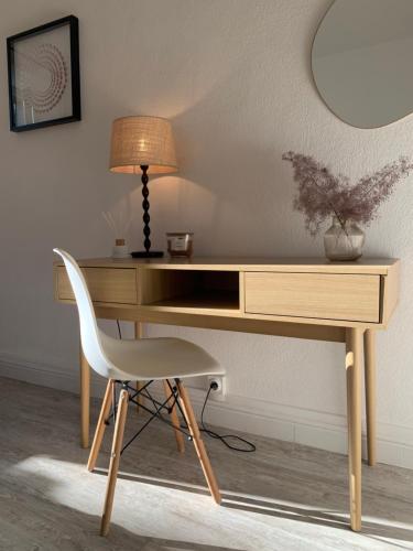 drewnianym biurkiem z lampką i krzesłem w obiekcie Charmant appartement de 120 m2 w mieście Aubenas