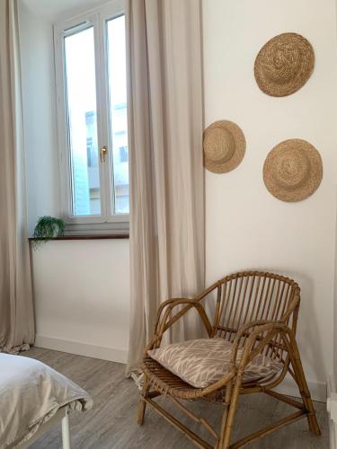 rattanowym krzesłem w sypialni z oknem w obiekcie Charmant appartement de 120 m2 w mieście Aubenas