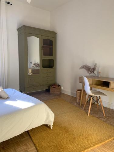 sypialnia z łóżkiem, biurkiem i krzesłem w obiekcie Charmant appartement de 120 m2 w mieście Aubenas