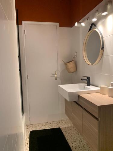 W łazience znajduje się umywalka i lustro. w obiekcie Charmant appartement de 120 m2 w mieście Aubenas