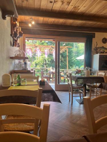 a dining room with tables and chairs and a large window at Trout Lodge in Collagna