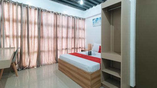 a bedroom with a bed and a book shelf at RedDoorz Near Iloilo International Airport in Iloilo City