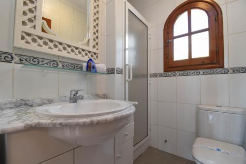 ein weißes Bad mit einem Waschbecken und einem WC in der Unterkunft Corto in Denia