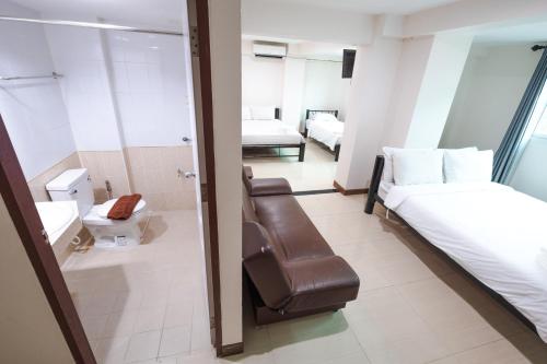 a room with a bed and a chair in it at Don Muang Hotel in Bangkok