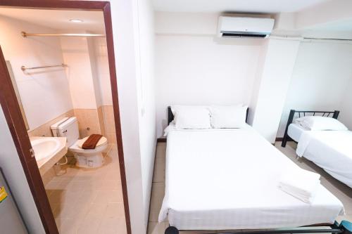 a small room with a bed and a toilet at Don Muang Hotel in Bangkok