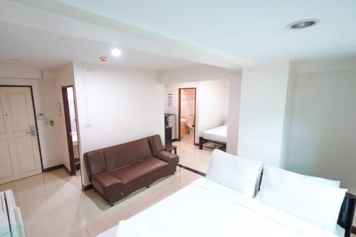 a living room with a couch and a bed at Don Muang Hotel in Bangkok