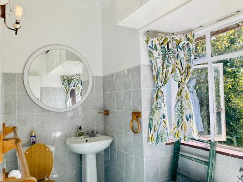 a bathroom with a sink and a mirror at Su Casa Scottsville in Pietermaritzburg