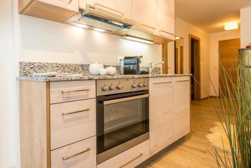 a kitchen with wooden cabinets and a stove top oven at smartFLATS in Dorfgastein
