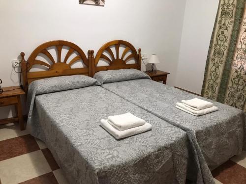 1 dormitorio con 1 cama con 2 toallas en Casa Carrión Caminito del Rey, en Bermejo