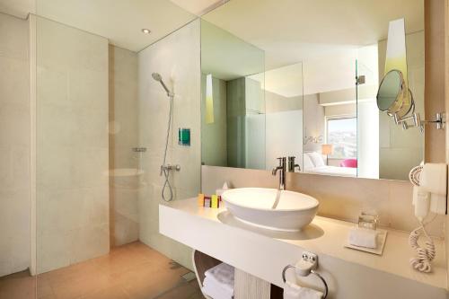 a white bathroom with a sink and a shower at ibis Styles Jakarta Gajah Mada in Jakarta