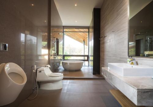 y baño con 2 lavabos, aseo y bañera. en Gliding Villa in Khao Yai, en Mu Si