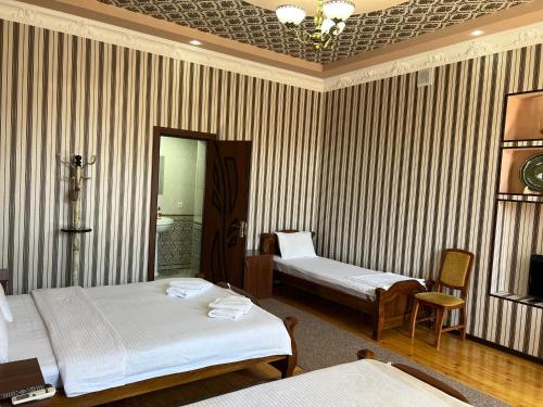 Habitación de hotel con 2 camas y espejo en SHAHNOZA GRAND, en Samarkand