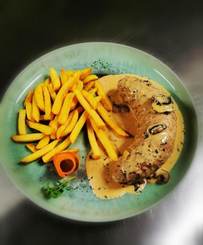 a plate of food with meat and french fries at Pension Restaurant Luna in Treis-Karden