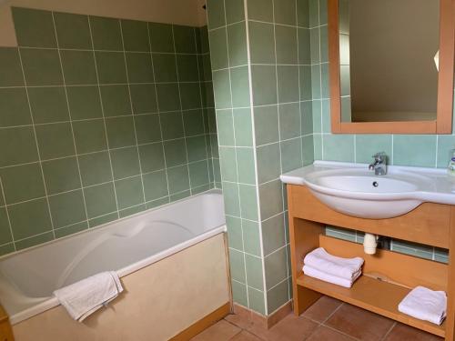 a bathroom with a sink and a tub and a mirror at Cottage Duplex golf de Limère prox Orléans in Ardon