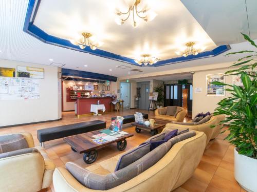 a living room with couches and a table at Tabist Sasebo Palace Hotel in Sasebo