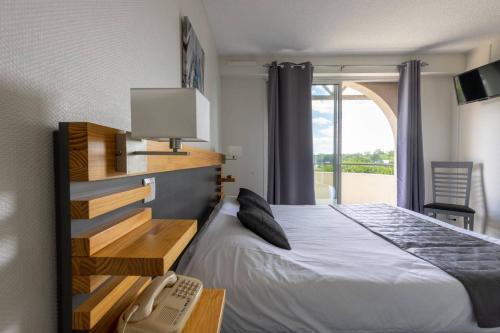 een slaapkamer met een bed, een telefoon en een raam bij Hotel Abor in Saint-Pierre-du-Mont