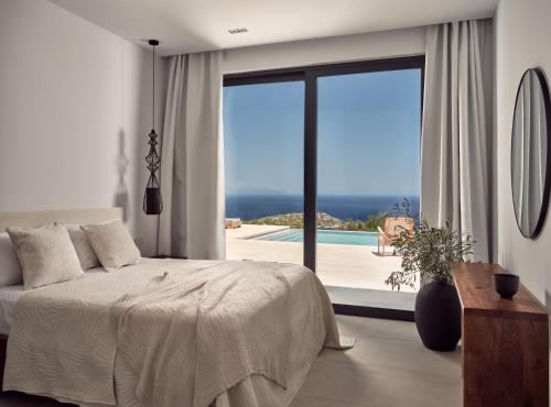 a bedroom with a bed and a view of a pool at Veda Villa in Agios Nikolaos