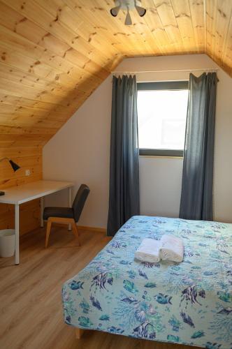 a bedroom with a bed and a desk and a window at Morski Las in Ustronie Morskie