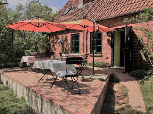 un patio con mesa, 2 sillas y sombrilla en Privelacker Paradiesgarten 