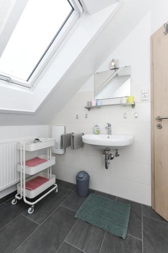 a bathroom with a sink and a mirror and a window at Ferienwohnungen Haus Hasenweide in Stedesdorf