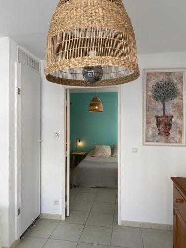 Cette chambre comprend un lit et un grand plafond en osier. dans l'établissement Beau Rivage, à Cavalaire-sur-Mer