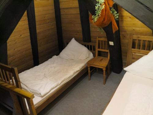 a small bed and a chair in a room at Ferienwohnung Flurerturm in Beilngries