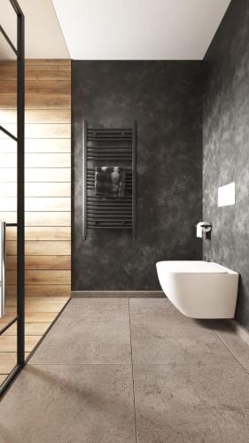 a bathroom with a white tub and a black wall at FLH - The Nest in Şelimbăr