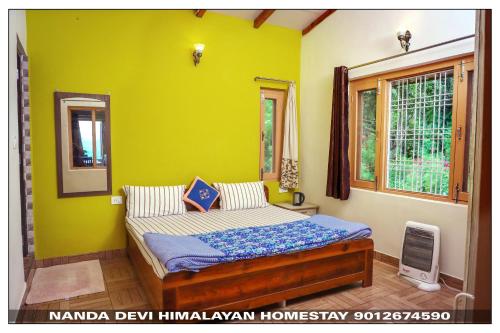 ein Schlafzimmer mit einem Bett mit gelber Wand in der Unterkunft Entire 2 BHK Nanda Devi Himalayan Homestay in Rānīkhet