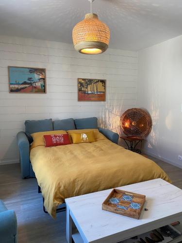 a bedroom with a bed and a table in it at Villa Paulownia - à 1,2km des plages - tout confort au coeur du bourg in Jard-sur-Mer