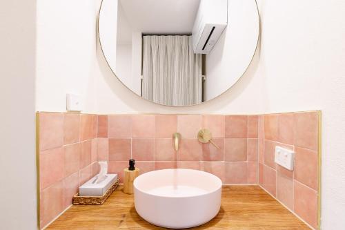 Richmond Inn في ريتشموند: حمام مع حوض أبيض ومرآة