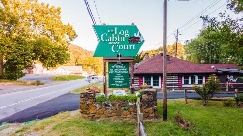 a sign for a log cabin restaurant on a street at Log Cabin Motor Court in Asheville