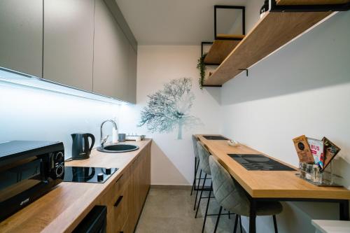- une cuisine avec un comptoir en bois et un évier dans l'établissement Studio apartman Golden Lux, à Pale