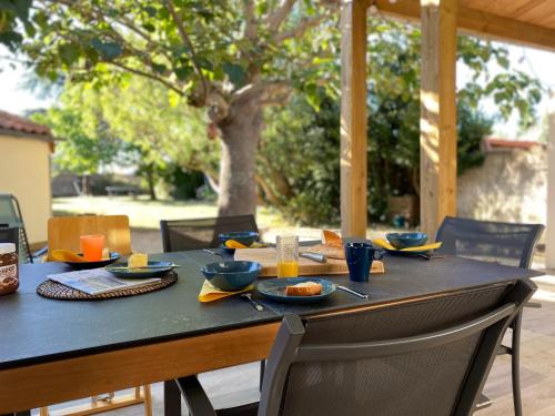 una mesa con platos de comida encima en Villa Paulownia - à 1,2km des plages - tout confort au coeur du bourg en Jard-sur-Mer