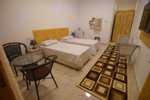 a bedroom with a bed and a table and chairs at السكون لبيوت الضيافة و شاليه AL Sukun For Guest Houses & Chalet in Al Ḩadd