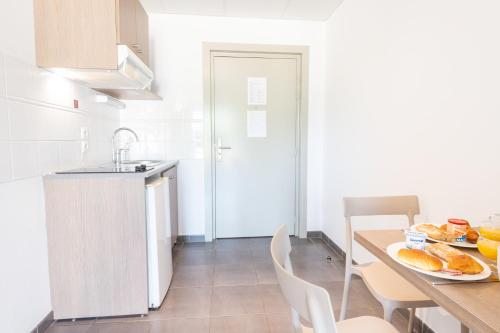 a kitchen with a table with a plate of food on it at Comfort Aparthotel Cannes Mandelieu in Mandelieu-la-Napoule