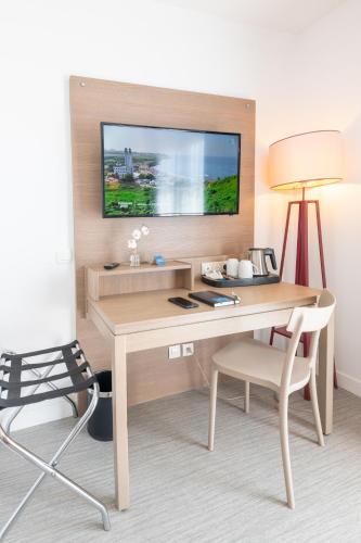 a room with a desk with a lamp and a chair at Comfort Aparthotel Cannes Mandelieu in Mandelieu-la-Napoule