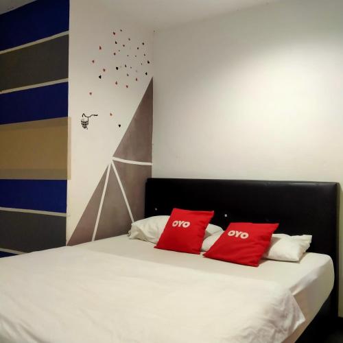 zwei rote Kissen auf einem Bett in einem Zimmer in der Unterkunft 1st Inn Hotel Glenmarie in Shah Alam