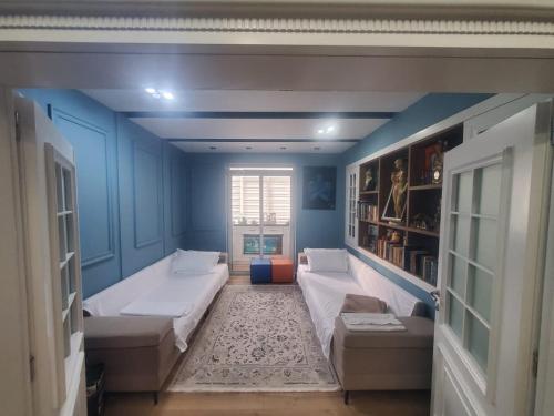 Habitación azul con 2 camas y sofá en Apartamenti8 Korca en Korçë