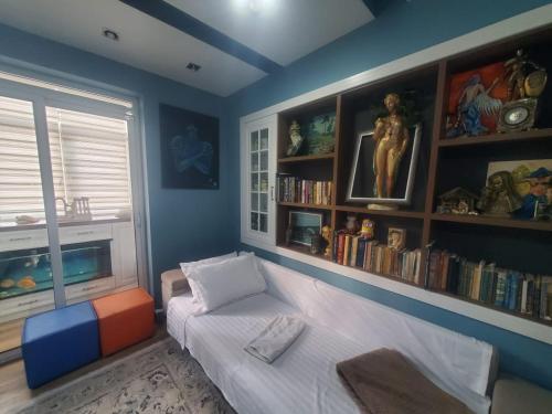 ein Wohnzimmer mit Sofa und Bücherregal in der Unterkunft Apartamenti8 Korca in Korçë